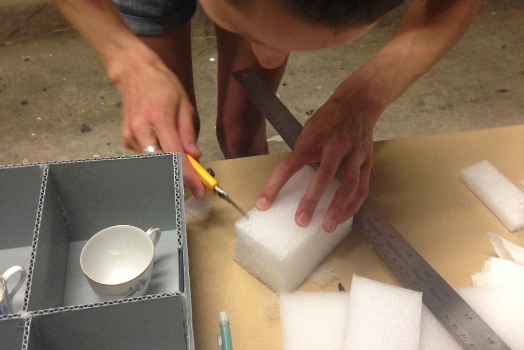 Student cuts foam to pack art objects