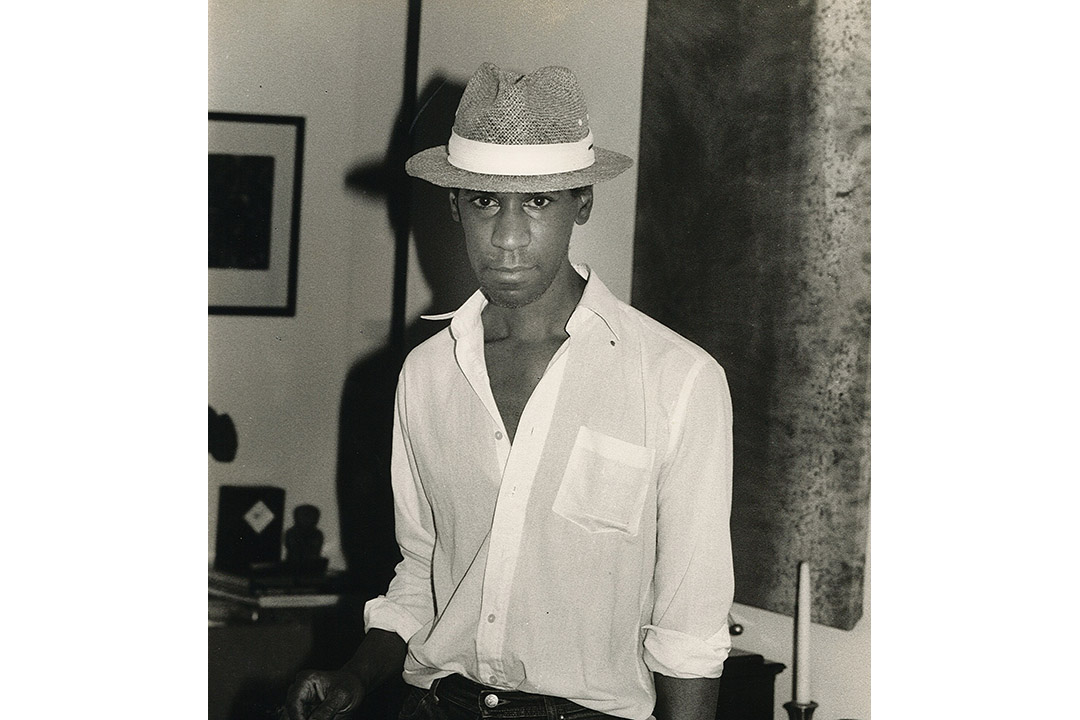 Black and white photograph of man in hat and white shirt