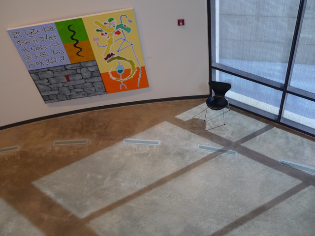 Painting seen from above with an empty chair and shadows on the right side