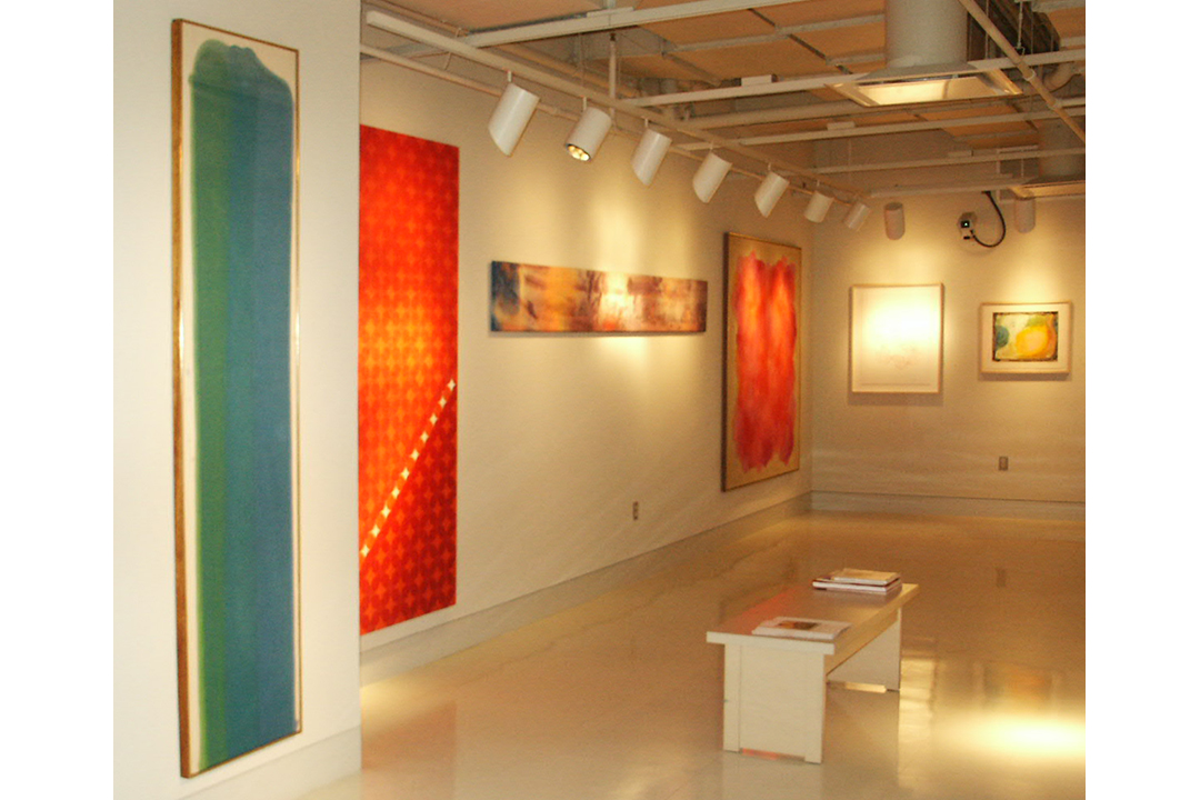 Very colorful paintings installed in a gallery
