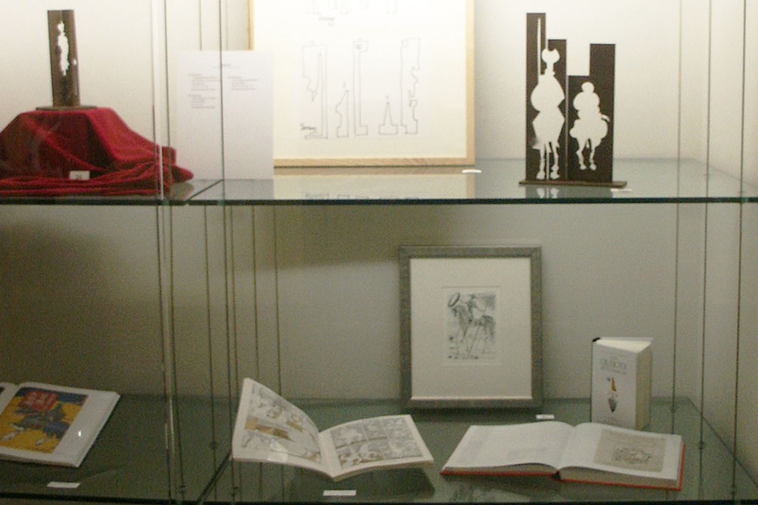 Small sculptures and books installed in a glass case