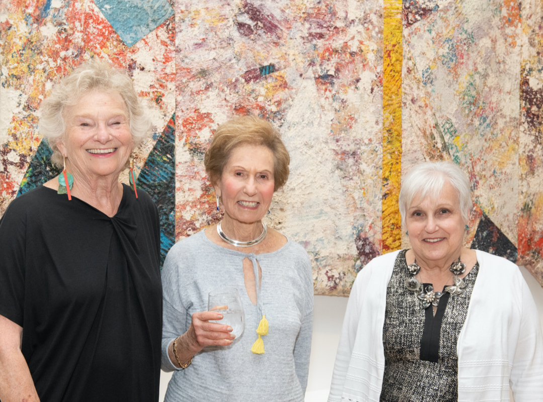 3 women in front of painting